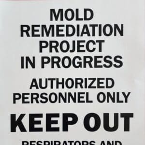 Danger sign for mold remediation, authorized personnel only.