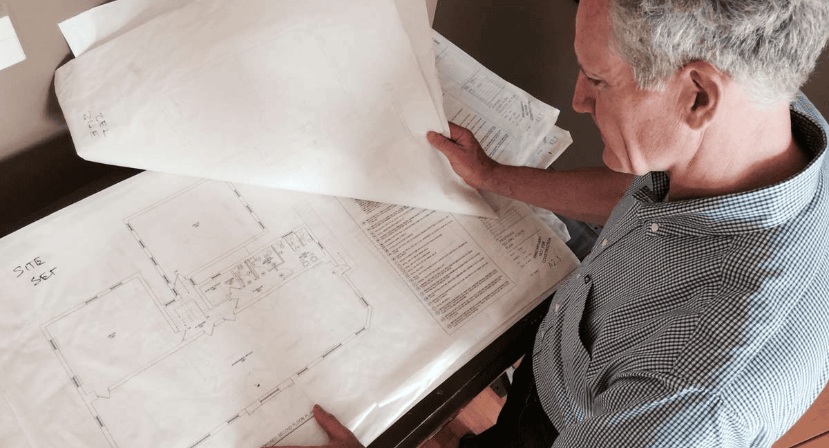 Architect reviewing building blueprints on a table.