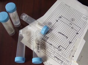 Blueprint and test tubes on a table for a research project.